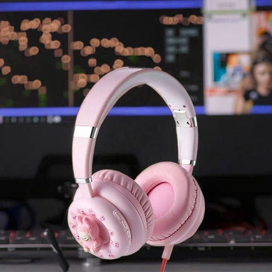Pink headphones with a unique design on a blurred background of a computer screen.
